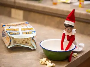 Elf stealing the popcorn and putting in a bowl